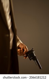 Male detective spy killer holding pistol gun in dramatic novel book cover design color photo.