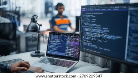 Male Developer Crafting Ai Code on Dual Monitors in a Contemporary Office. Emphasizes Programming Expertise, Analytical Acumen, and Innovative Software Solutions in Artificial Intelligence.