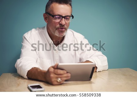 Male IT developer testing new application for digital devices creating programs and software via touchpad using wireless connection in office sitting near copy space area for your advertising