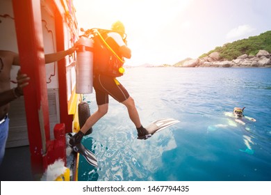 Male diver jumps into the sea from a yacht