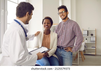 Male Doctor Comfort Support Multiracial Couple Patients At Consultation In Clinic. Man Gynecologist Caress Show Help Understanding To Ethnic Family At Hospital Appointment. Good Medicine Concept.