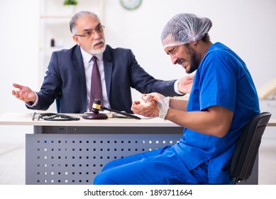 Male Doctor In Courthouse Meeting With Advocate