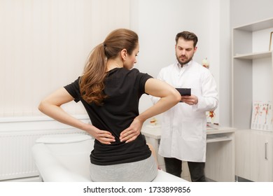 Male Doctor Examining Female Patient Suffering From Back Pain. Medical Exam. Chiropractic, Osteopathy, Post Traumatic Rehabilitation, Sport Physical Therapy. Alternative Medicine, Pain Relief Concept.