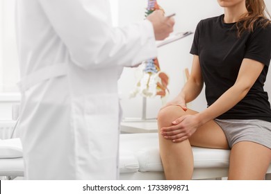 Male Doctor Examining Female Patient Suffering From Knee Pain. Medical Exam. Chiropractic, Osteopathy, Post Traumatic Rehabilitation, Sport Physical Therapy. Alternative Medicine, Pain Relief Concept.