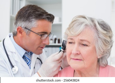 Médecin masculin examinant des patientes porteuses d'un otoscope à la clinique