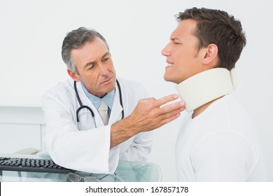 Male doctor examining a patient at desk in medical office