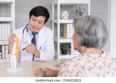 Male Doctor Explaining Anatomical Feet With Elderly Patient Asian Woman In Hospital 