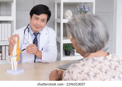 Male Doctor Explaining Anatomical Feet With Elderly Patient Asian Woman In Hospital 