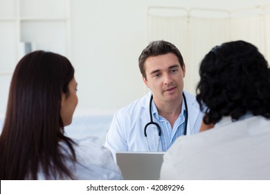 Male Doctor Explaining Diagnosis To A Couple During A Visit