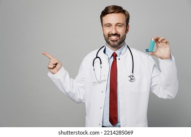 Male Doctor Fun Man Wears White Medical Gown Suit Work In Hospital Hold In Hand Inhaler Point Finger Aside On Area Isolated On Plain Grey Color Background Studio Portrait. Healthcare Medicine Concept