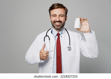 Male Doctor Fun Man Wears White Medical Gown Suit Work In Hospital Hold Medication Tablets, Aspirin Pills In Bottle Isolated On Plain Grey Color Background Studio Portrait. Healthcare Medicine Concept