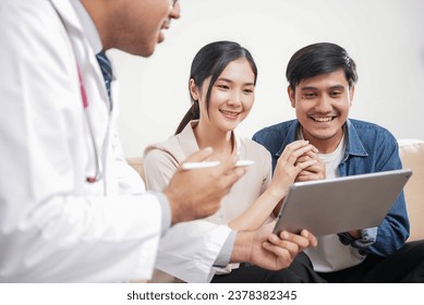 Male doctor giving test result to asian couple patient with tablet. They feeling happy and holding hand together when received good news from the doctor in medical office, hospital, clinic or home. - Powered by Shutterstock