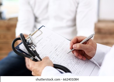 Male Doctor Hand Hold Silver Pen Filling Patient History List At Clipboard Pad. Physical, Exam, Er, Disease Prevention, Ward Round, Visit Check, 911, Prescribe Remedy, Healthy Lifestyle Concept