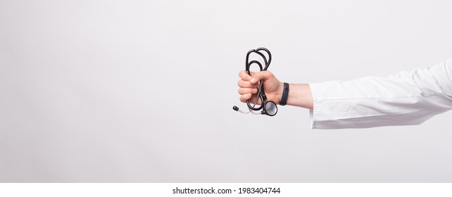 Male doctor hand holding Stethoscope over white background.