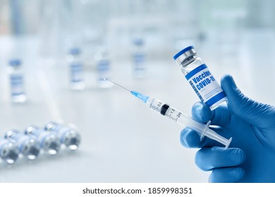 Male doctor hand wears medical glove holding syringe and vial bottle with covid 19 corona virus vaccine drug multiple dose for injections. Coronavirus cure, flu medicine treatment vaccination concept.