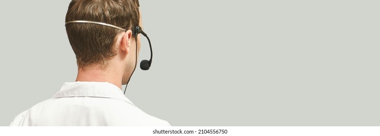 Male Doctor With Headphones. Studio Medicine Portrait. Clinic Online Help. Health Support Call. Telemarketing Agent Microphone. Multi-language Translator. Telemedicine Equipment. Back View. Copyspace