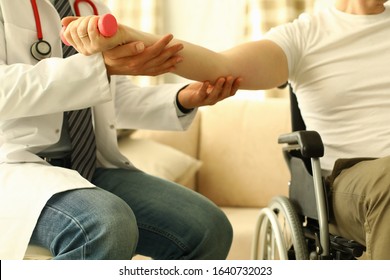 Male doctor helps lift dumbbell to disabled patient rehabilitation therapy concept. Process of recovering patients after severe injuries - Powered by Shutterstock