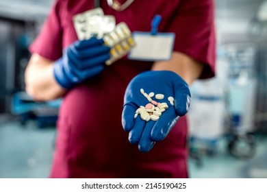 Male Doctor Holding  Pack Of Different Tablet Pills In Hospital Room. Disease Healing Concept