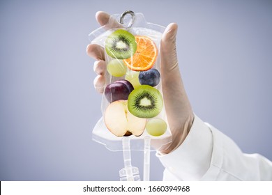 Male Doctor Holding Saline Bag With Fruit Slices Inside In Hospital