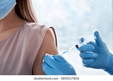 Мужской врач держит шприц, делая инъекционную дозу вакцинации covid 19 в плечо пациентки. Концепция клинических испытаний вакцины против гриппа, побочный эффект лечения вируса короны, вакцинация. 