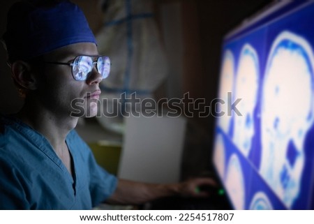 male doctor looks at a monitor with an MRI image of the vessels of the brain - this is a highly informative procedure aimed at screening the circulatory system in the human head.