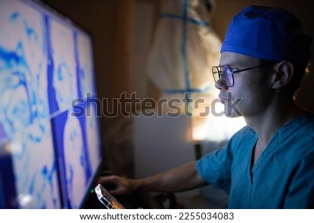 male doctor looks at a monitor with an MRI image of the vessels of the brain - this is a highly informative procedure aimed at screening the circulatory system in the human head.