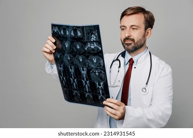 Male doctor man wears white medical gown suit work in hospital hold x-ray radiographic image ct scan head brain mri isolated on plain grey color background studio portrait. Healthcare medicine concept - Shutterstock ID 2314931545