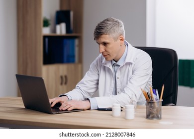 Male Doctor In Medical Uniform Working Typing On Computer. Family Therapist Consulting Patients Online Through Digital Health Platform.