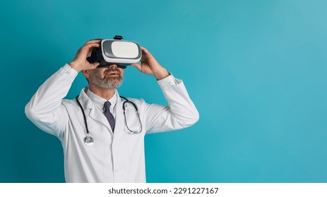 Male doctor middle aged man wearing virtual reality glasses isolated on blue studio background, panorama with copy space. Future medicine and modern technologies gadgets concept - Powered by Shutterstock
