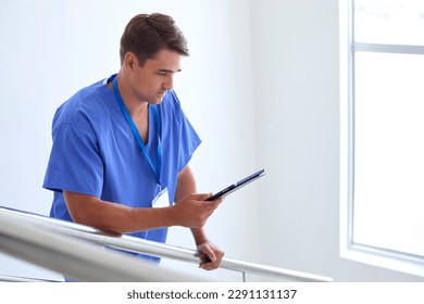 Male Doctor Or Nurse With Digital Tablet Checking Patient Notes On Stairs In Hospital - Powered by Shutterstock