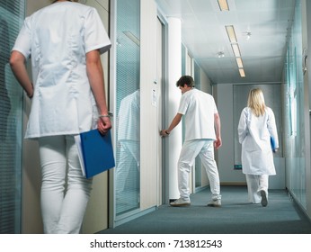 Male Doctor Opening Door In A Lobby