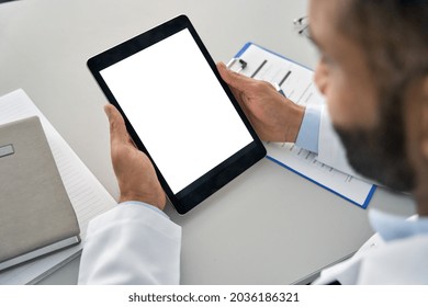 Male Doctor Physician Medical Worker Holding Digital Tablet In Hands Looking At White Blank Empty Mockup Screen Working In Hospital. E Health Technology Mock Up Concept. Over Shoulder View