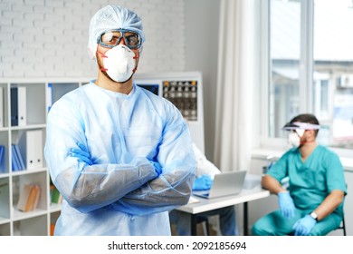 Male Doctor In Protective Medical Gown Standing In Hospital Cabinet