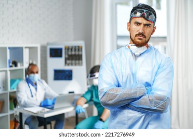 Male Doctor In Protective Medical Gown Standing In Hospital Cabinet