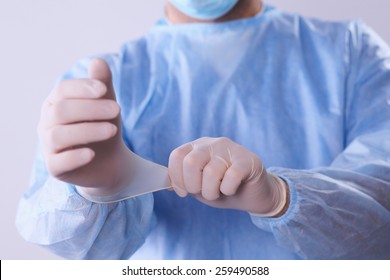 Male Doctor Putting On Disposable Gloves