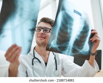 Male Doctor Radiologist Examines X-rays In A Medical Office.