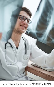 Male Doctor Radiologist Examines X-rays In A Medical Office.