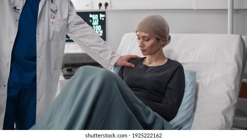 Male Doctor Recommend Patient Using Chemotherapy As Way To Help Control Cancer. Senior Oncologist Showing Test Results On Clipboard To Sick Woman Resting On Bed In Hospital Ward