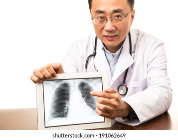 Male doctor showing a digital x-ray image on a tablet - Powered by Shutterstock