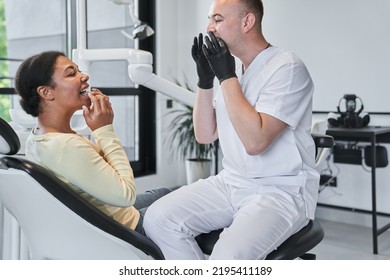 Male Doctor Showing To His Female Patient How To Wear Transparent Tray