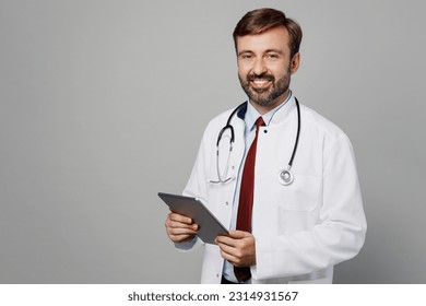 Male doctor smiling man wears white medical gown suit stethoscope work in hospital tablet pc computer look camera isolated on plain grey color background studio portrait. Healthcare medicine concept - Shutterstock ID 2314931567