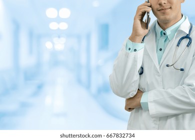 Male Doctor Speaking On Mobile Phone In A Hospital Or Office. Concept Of Call Center, Medical Consultation.