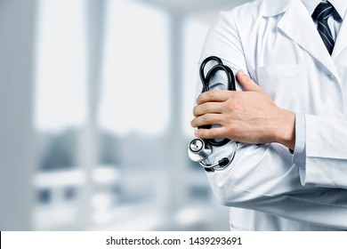 Male doctor with stethoscope on blurred hospital