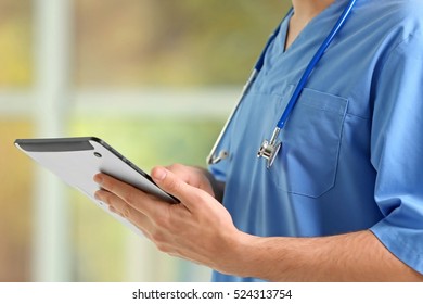 Male doctor with tablet in hands, closeup