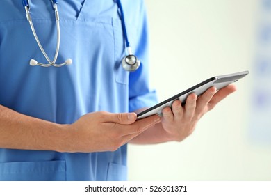 Male doctor with tablet in hands, closeup