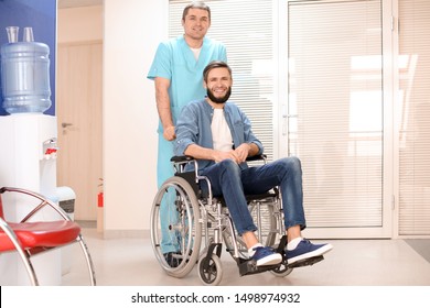 Male doctor taking care of man in wheelchair indoors - Shutterstock ID 1498974932