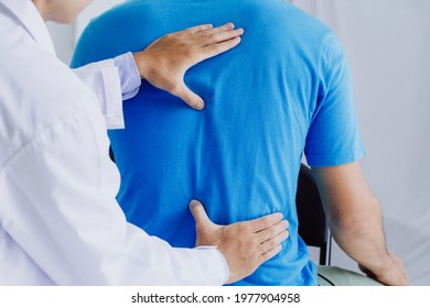 Male doctor therapist doing healing treatment on man's back.Back pain patient, treatment, medical doctor,massage for back pain relief office syndrome