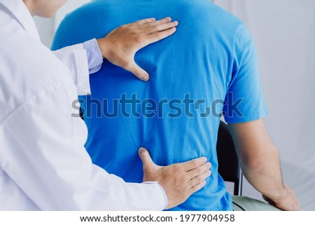 Male doctor therapist doing healing treatment on man's back.Back pain patient, treatment, medical doctor,massage for back pain relief office syndrome
