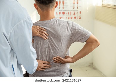 Male doctor therapist working examining treating injured back.Back pain patient, treatment, medical doctor,massage for back pain relief office syndrome. - Powered by Shutterstock