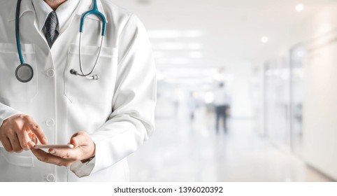 Male Doctor Using Mobile Phone At Hospital. Medical Healthcare And Doctor Service.